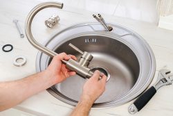 Close-up,Plumber,Hands,Holds,A,New,Faucet,For,Installing,Into